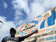 Na Costa do Marfim, o dono de um matadouro chamado "Casa Branca" posa ao lado do cartaz do estabelecimento, em comemoração à reeleição do presidente norte-americano 