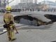 Um bombeiro observa e isola uma cratera que se formou em plena&nbsp;avenida da cidade de Taiyuan, na China. As causas do buraco de 6 metros de largura e 10 de profundidade estão sendo investigadas