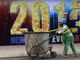 Lixeira vietnamita passa por cartaz em Hanói que celebra a chegada de 2013