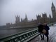 Casal passeia sobre a ponte Westminter, no centro de Londres, durante nevasca