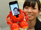 Funcionária da fábrica de brinquedos japonesa Tomy mostra novo robô durante coletiva de imprensa em Tóquio. Feito para ser usado com um iPhone, o robô reage à música e dança