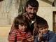 Pai abraça seus dois filhos no campo de refugiados de Azaz