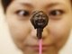 Japonesa observa escultura do próprio rosto feita com chocolate neste sábado (9) em Tóquio, capital do país