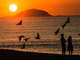 Casal observa o nascer do sol na praia de Copacabana, no Rio de Janeiro