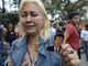Emocionada, venezuelana exibe imagem de Hugo Chávez para fotógrafos<br>
