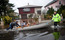 Um oficial ajuda duas pessoas e seu cachorro a abandonar seu bairro, depois que o local foi inundado por causa da supertempestade Sandy.<br><br>O presidente Barack Obama classificou Sandy como um “enorme desastre”<br><br>