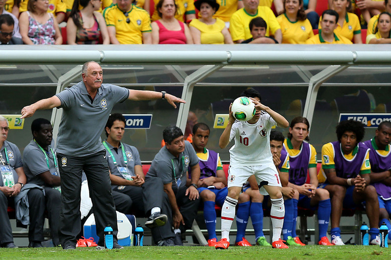 A seleção do Japão não se intimidou com o gol brasileiro logo no início da partida e foi para cima do Brasil; na foto, meia japonês cobra lateral enquanto Felipão orienta equipe nacional 