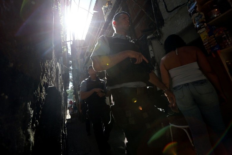 Policiais da UPP caminham em um dos becos da Rocinha em busca de suspeitos