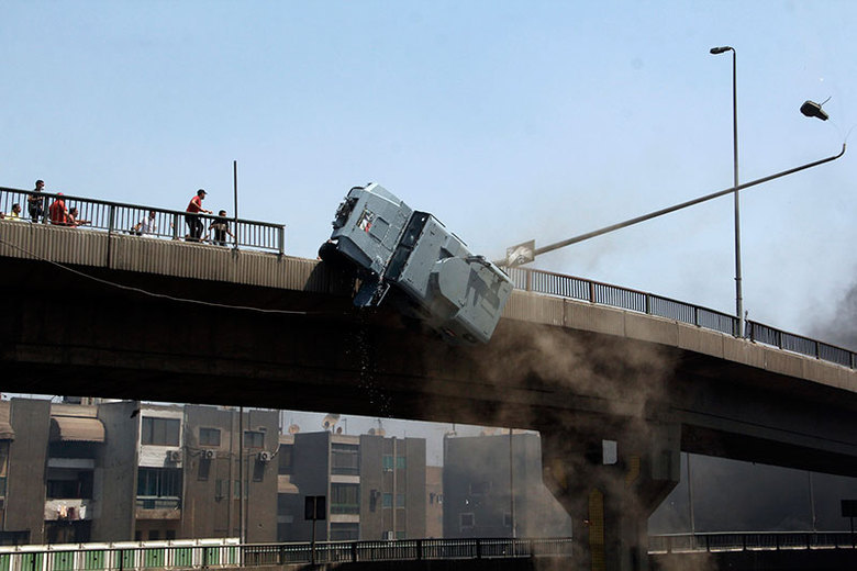 Manifestantes pró-Mursi jogaram um carro de polícia de cima da ponte 6 de Outubro, no Cairo