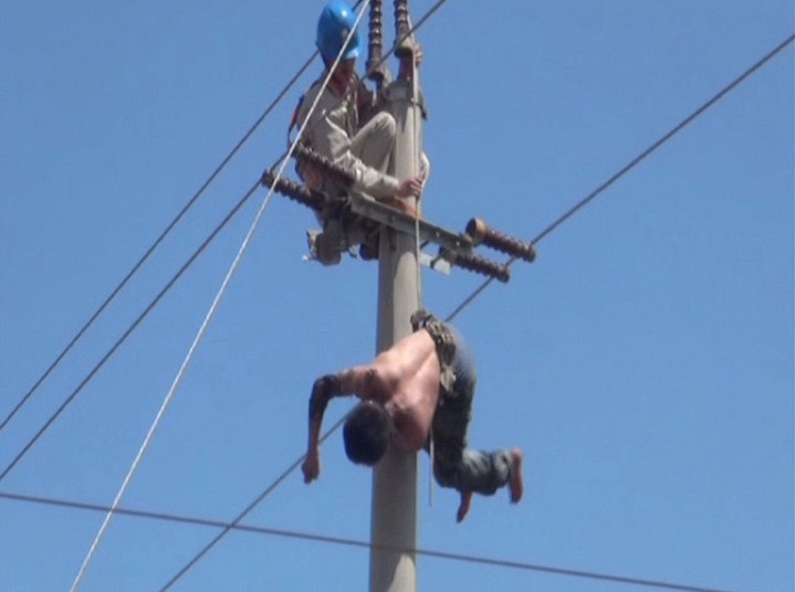 Quando olhou para cima, lá estava o homem, de 28 anos, pendurado de cabeça para baixo. Seus pés o salvaram ao ficarem presos na estrutura do poste