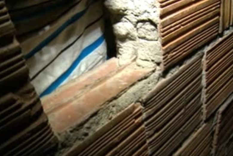 Espaço pequeno por onde a mãe coloca comida para o filho viciado em crack há 18 anos. Mãe disse que foi a única alternativa que ela encontrou para evitar que o filho morresse por dívidas com o tráfico 
