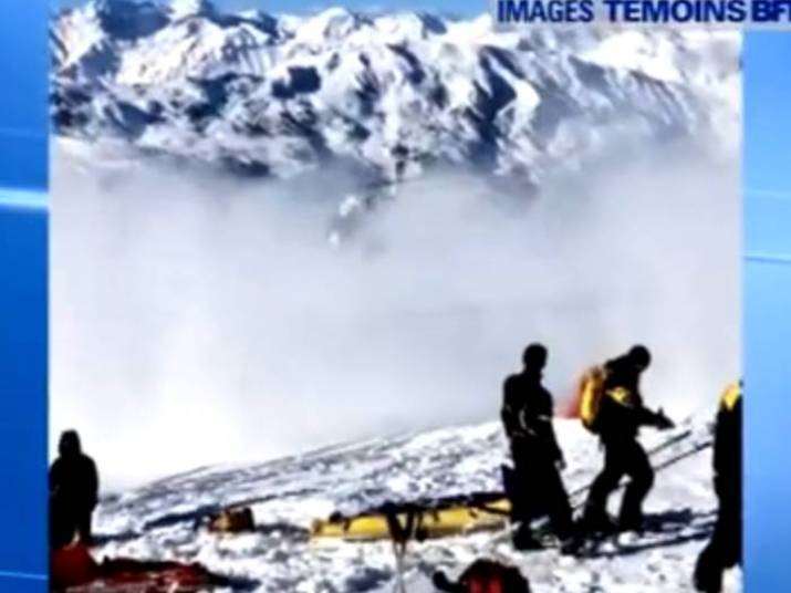 Na imagem, os esquiadores parecem consternados com o acidente e apenas observam o helicóptero partir 