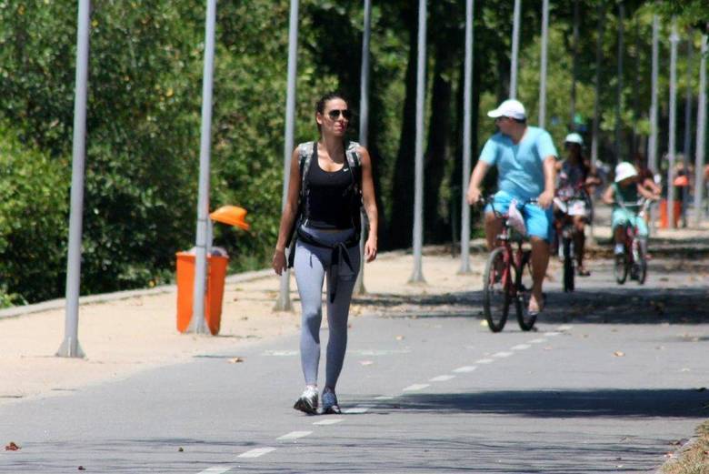 Na sequência de fotos, o ciclista aparece atrás de Mel Fronckowiak, pedalando tranquilamente