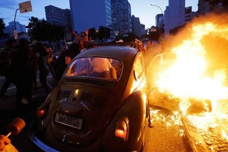 Vítimas tentam descer pelo lado esquerdo do carro enquanto o direito é consumido pelas chamas