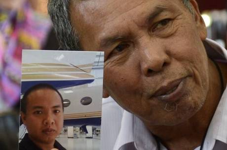 Selamat Omar mostra foto do filho, Mohd Khairul Amri Selamat, que estava a bordo do voo MH-370