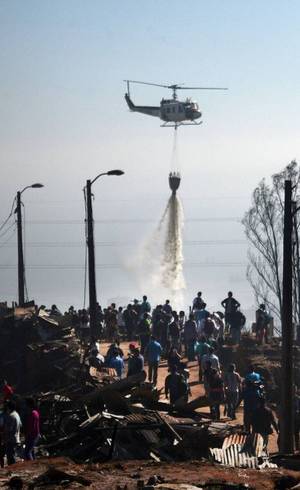 Helicóptero solta água sobre a região afetada