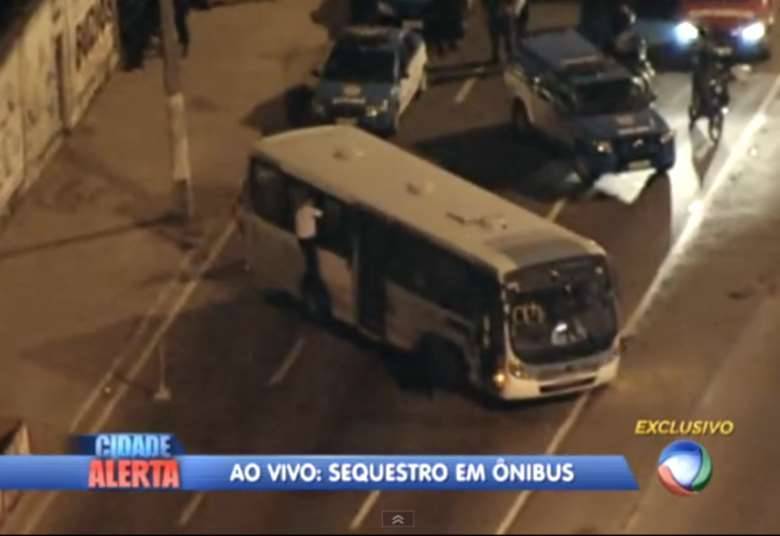 Policiais do BPVE (Batalhão de Vias Expressas) foram os primeiros a chegar ao local do crime. Um negociador do Bope (Batalhão de Operações Especiais) — na imagem, sobre o pneu do coletivo — dialoga com o criminoso para que os reféns sejam liberados