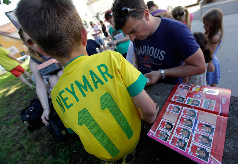 Um menino vestido com uma camiseta do Neymar troca figurinhas da Copa em um ponto de encontro de colecionadores na Liubliana, capital e maior cidade da Eslovênia