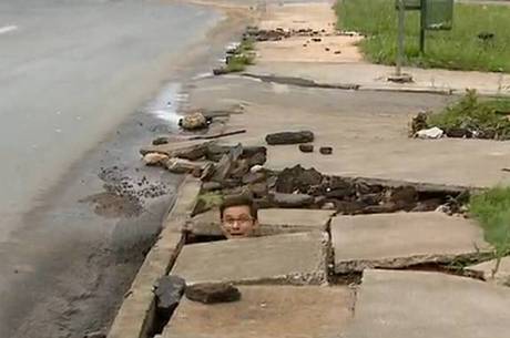 Repórter consegue se esconder dentro de buraco na calçada
