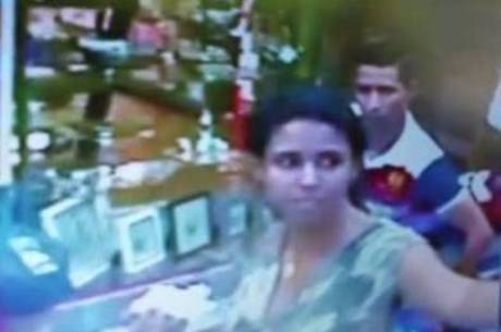 Imagem mostra o momento em que o homem pega o celular quando a dona de banca vira de costas