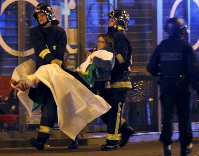 A banda de rock Eagles of Death Metal, que fez show na casa noturna Le Bataclán, escapou do atentado na noite desta sexta. O ataque, que aconteceu uma hora depois da apresentação, terminou com um massacre. Na foto, mulher é socorrida perto da casa de espetáculos