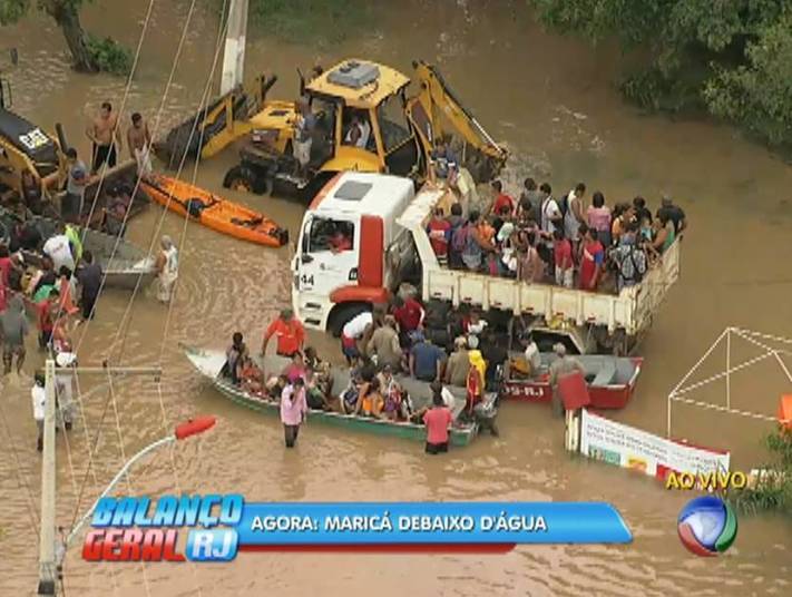 No início da tarde, moradores estavam sendo resgatados com auxílios de barcos, caminhões e retroescavadeira