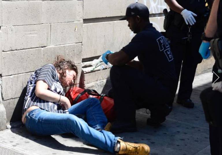 Uma mulher que estava sendo atendida por um policial estava quase inconsciente, com seus olhos virados para cima. Era um exemplo do estado deplorável em que foram encontrados