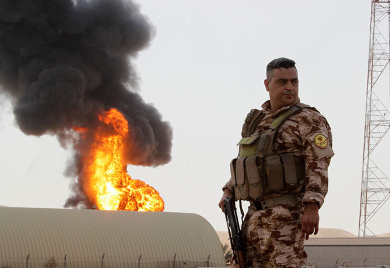 Membro do exército curdo patrulha a área, no Iraque, após ataque do Estado Islâmico. Ao menos cinco pessoas morreram após os atentados deste domingo (31). O Estado Islâmico atacou duas estações de energia hoje