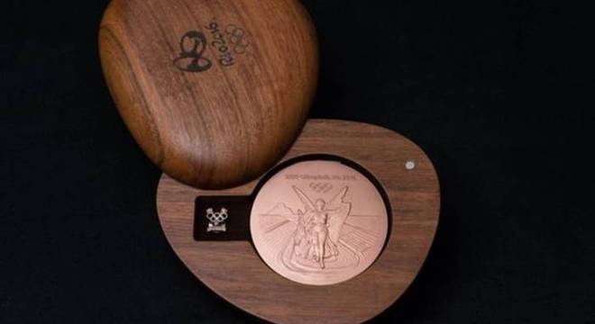 As medalhas vêm em uma caixa de madeira produzida de forma sustentável