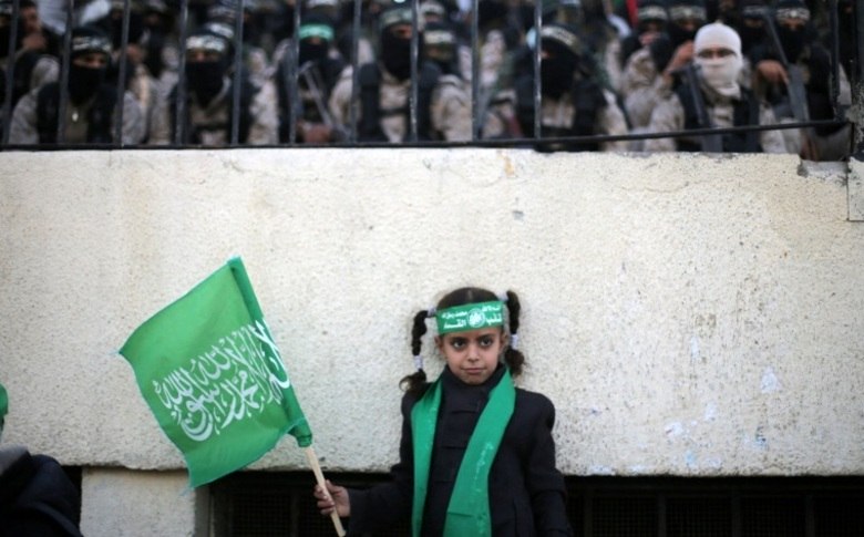 Era dezenas de crianças no desfile. Elas vestiam inclusive uniforme militar e bandanas verdes com o distintivo do grupo, trajes também utilizados por combatentes adultos
