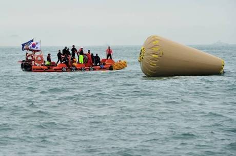 Equipes de resgate procuram desaparecidos perto de boia instalada para marcar o lugar em que está o navio afundado 