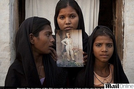 As filhas de Asia mostram a foto da mãe, que pode ser executada 