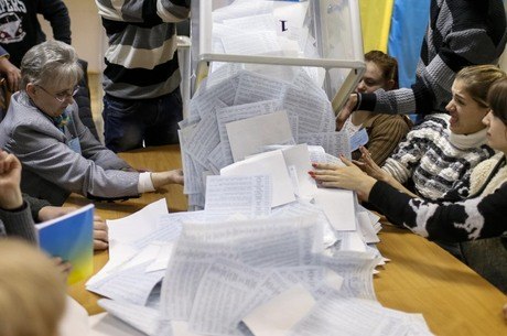 Membros de comissão eleitoral esvaziam urna em Kiev, na Ucrânia
