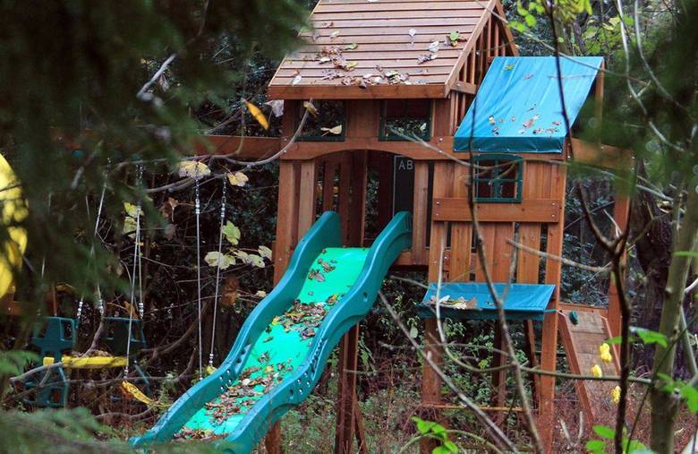 Quem passa de longe vê um monte de brinquedos espalhados e inutilizados, além da grama crescendo, lixo e carrinhos de bebê
