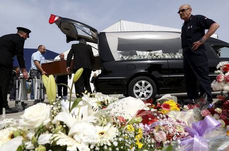 Caixão com corpo de vítima de naufrágio é colocado em carro funerário após homenagem 