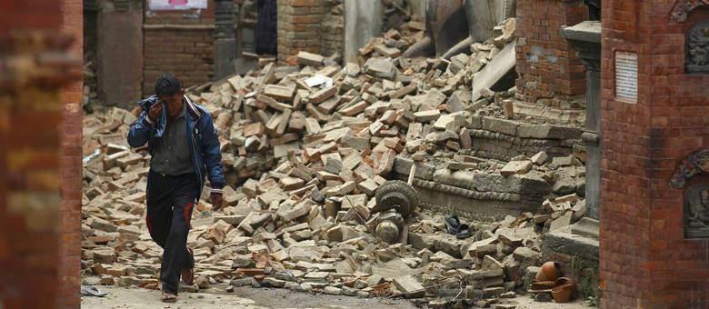 Homem chora em meio a escombros no Nepal