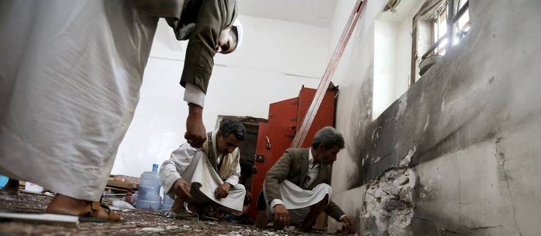 Homens observam danos causados por explosão de bomba em mesquita xiita de Sanaa, capital do Iêmen
