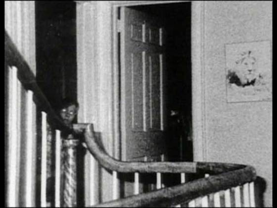 Um homem com uma cara assustadora está atrás de uma porta.