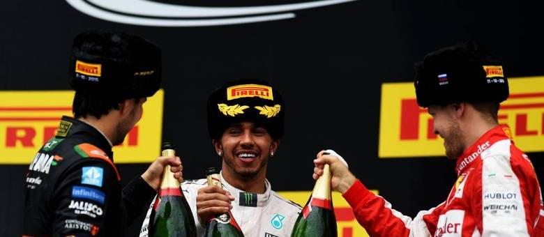 Hamilton celebrando mais uma vitória no pódio, desta vez ao lado de Pérez e Vettel 