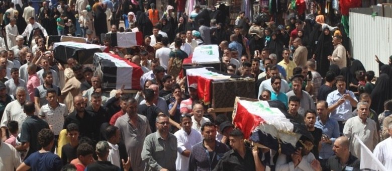 Familiares e amigos carregam caixões dos mortos no atentado em Bagdá
