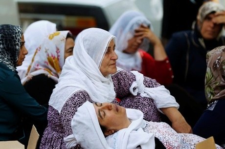 Mulheres choram enquanto esperam na frente do necrotério do hospital na cidade turca de Gaziantep
