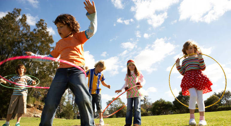 Crianças brincando de bambolê no parque Crianças brincando de bambolê no parque