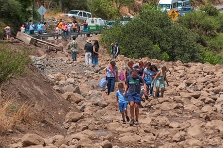 A população anda sobre uma rua atingida pelo deslizamento de terra na região de Santiago
