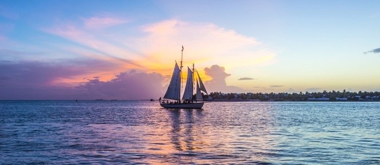 Veleiros desfilam ao pôr do sol, que é um verdadeiro Carnaval em Key West, na vista do pier