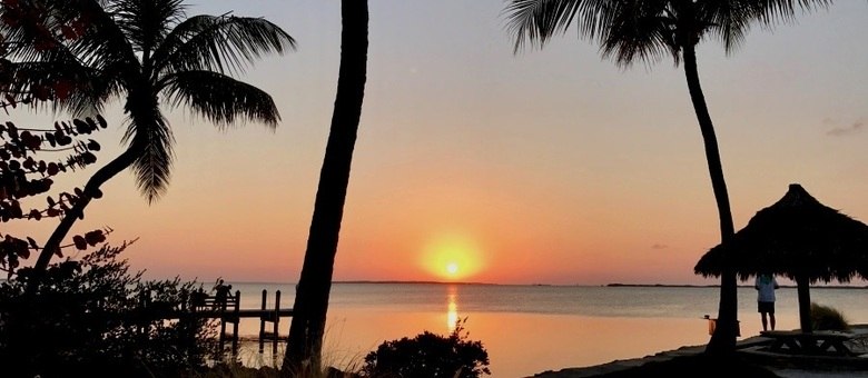 Pier com charme, rede, palmeiras e tudo o que se tem direito no pôr do sol do Kona Kai Resort, em Key Largo