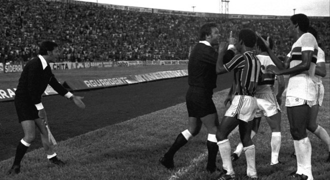Bandeirinha Vandevaldo Rangel (e), abaixa a meia para mostrar ao árbitro Oscar Scolfaro e aos jogadores a marca na canela após levar chute de Serginho Chulapa