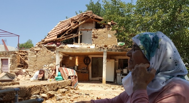 Uma mulher vê sua casa danificada após terremoto na vila de Yaliciftlik, perto da cidade turística de Bodrum, na Turquia
