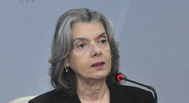 Carmen trabalhou todo o tempo instalada em uma mesa redonda Carmen trabalhou todo o tempo instalada em uma mesa redonda