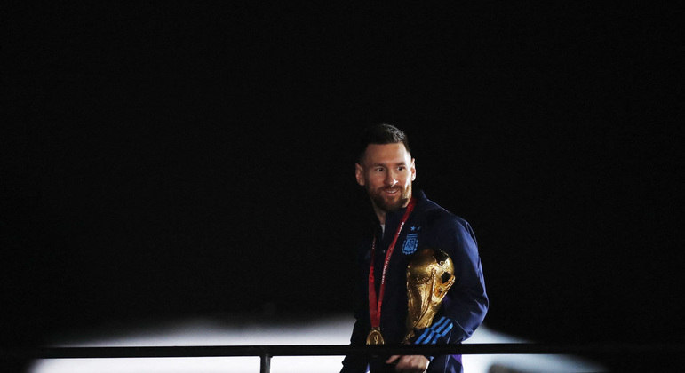 Messi com a taça da Copa do Mundo, durante a chegada da delegação ao país
