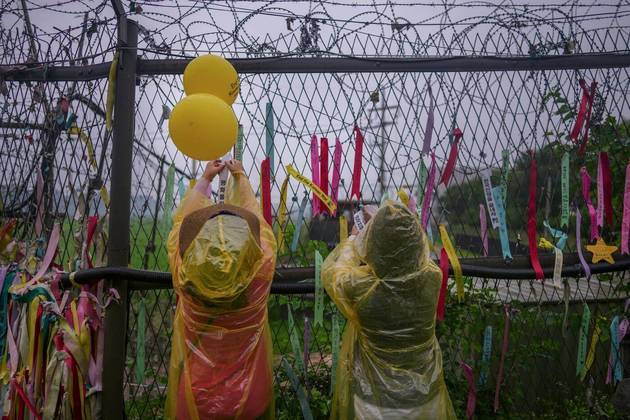 Visitantes penduram fitas com mensagens que pedem paz e reunificação em um parque perto da DMZ, em Imjingak, na Coreia do Sul, 23 dejulho de 2022. O parque possui muitas estátuas e monumentos relacionados àGuerra da Coreia